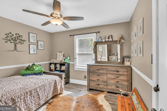 bedroom featuring wood finished floors, baseboards, and a ceiling fan