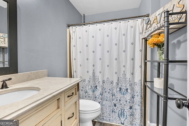 bathroom with toilet, vanity, a shower with curtain, and wood finished floors