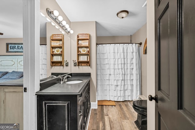 full bath with wood finished floors, vanity, toilet, and curtained shower