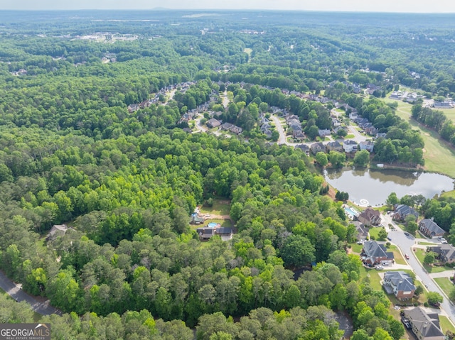 aerial view of property's location featuring a forest and a nearby body of water