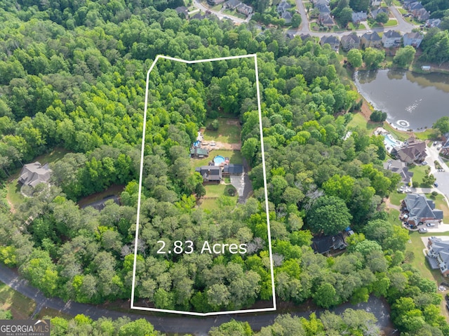 aerial view of property and surrounding area with property parcel outlined and a nearby body of water