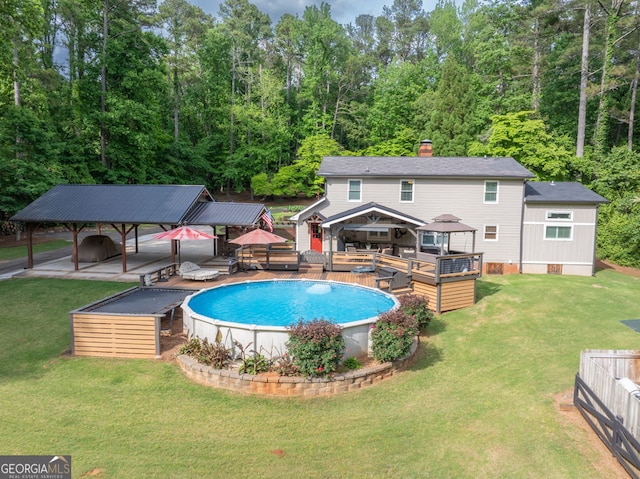 swimming pool featuring a gazebo, a wooden deck, and a yard
