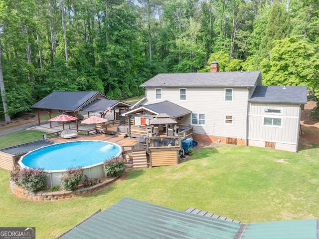 swimming pool featuring a gazebo, a deck, and a lawn