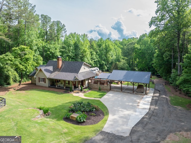 aerial view of property and surrounding area featuring a heavily wooded area