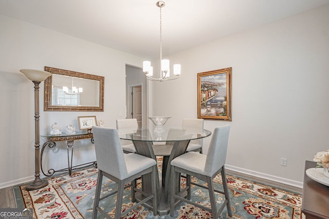 dining area with a chandelier, baseboards, and wood finished floors