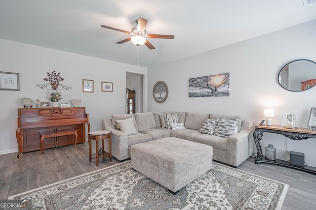 living room with a ceiling fan, wood finished floors, and baseboards