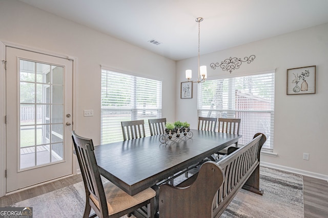 dining room featuring wood finished floors, a chandelier, and baseboards