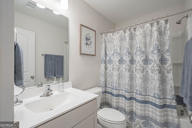 bathroom featuring toilet, vanity, and a shower with curtain