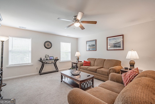 living room with a ceiling fan, baseboards, and carpet