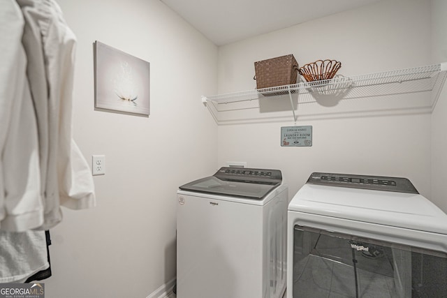 laundry room featuring washing machine and clothes dryer and baseboards