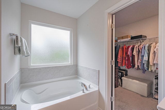 full bathroom featuring a garden tub and a walk in closet