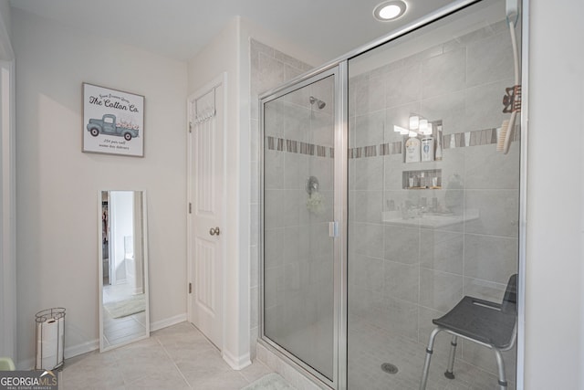 bathroom featuring a stall shower, tile patterned flooring, and baseboards