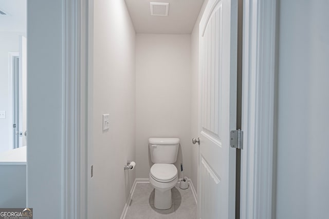 bathroom with toilet, baseboards, and tile patterned floors