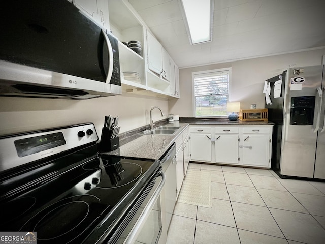 kitchen featuring stainless steel appliances, a sink, white cabinets, dark countertops, and light tile patterned flooring