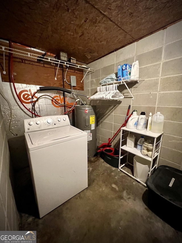 laundry room featuring washer / dryer, water heater, and concrete block wall