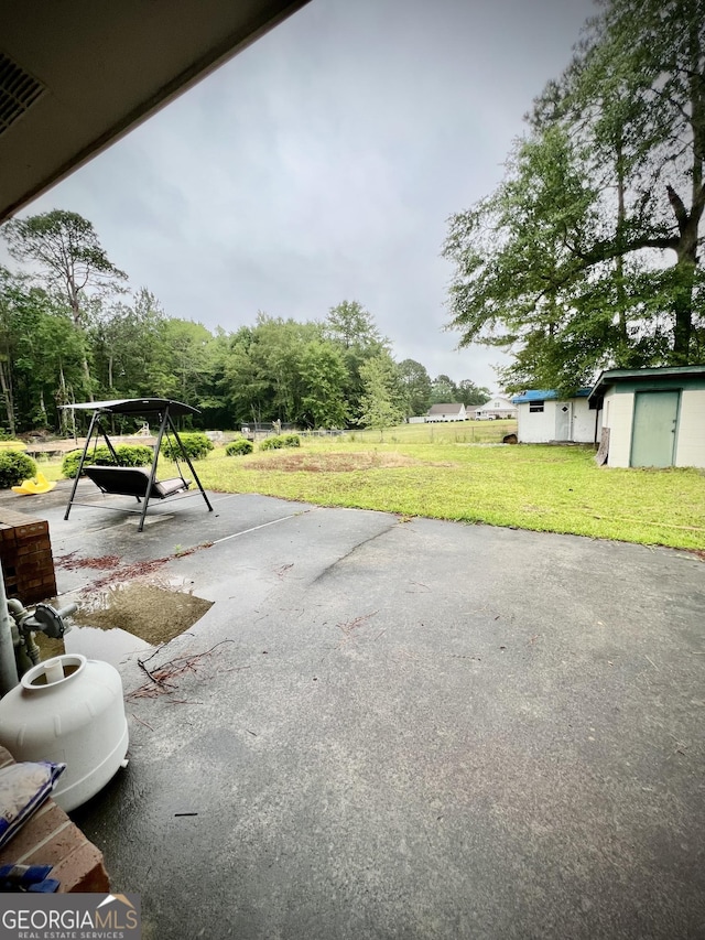 view of patio / terrace with an outdoor structure and a shed
