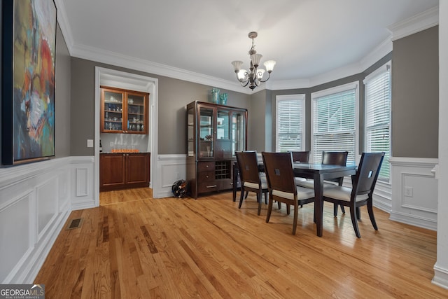 6217 Millstone Trl, Douglasville, GA 30135 - dining space with a chandelier, ornamental molding, light wood-type flooring, a decorative wall, and wainscoting