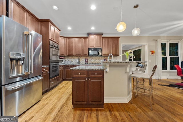 6217 Millstone Trl, Douglasville, GA 30135 - kitchen with appliances with stainless steel finishes, light wood-type flooring, a kitchen bar, backsplash, and crown molding