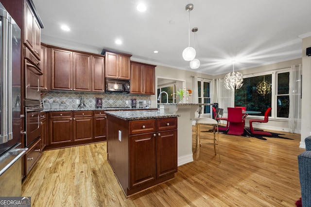 6217 Millstone Trl, Douglasville, GA 30135 - kitchen featuring stainless steel appliances, a breakfast bar, ornamental molding, a center island with sink, and tasteful backsplash