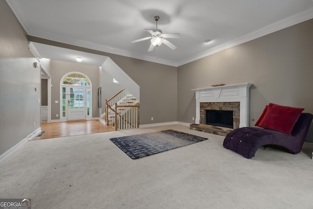 6217 Millstone Trl, Douglasville, GA 30135 - carpeted living area with stairs, ornamental molding, baseboards, a ceiling fan, and a stone fireplace