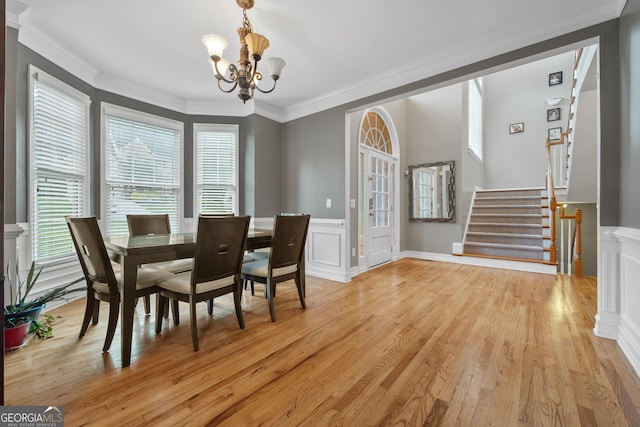 6217 Millstone Trl, Douglasville, GA 30135 - dining area with a chandelier, ornamental molding, plenty of natural light, stairway, and light wood finished floors