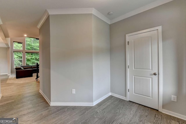 unfurnished room with wood finished floors, baseboards, and a smoke detector