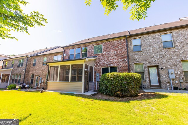 9872 Cameron Parc Cir, Johns Creek, GA 30022 - rear view of house featuring a sunroom, a yard, and brick siding