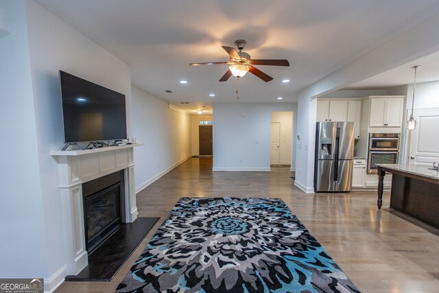 9872 Cameron Parc Cir, Johns Creek, GA 30022 - living room with a ceiling fan, wood finished floors, a glass covered fireplace, recessed lighting, and baseboards