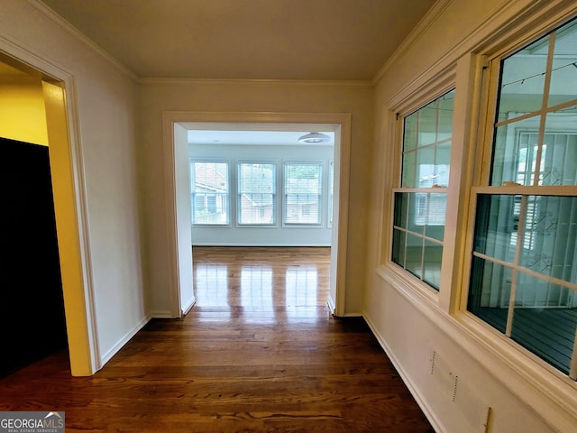 corridor with dark wood-style floors, crown molding, and baseboards