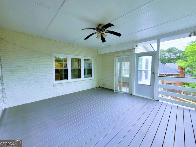 unfurnished sunroom with a ceiling fan