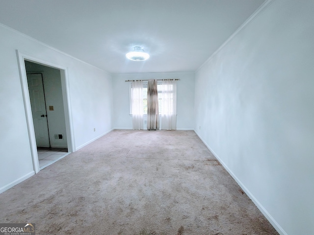 empty room featuring ornamental molding, carpet flooring, and baseboards