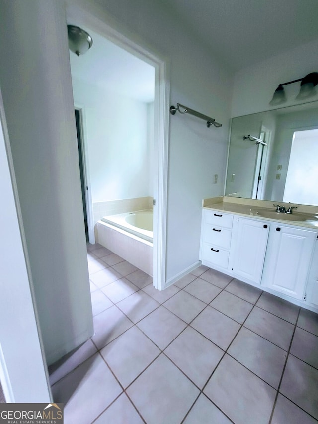full bath with tile patterned floors, double vanity, and a garden tub