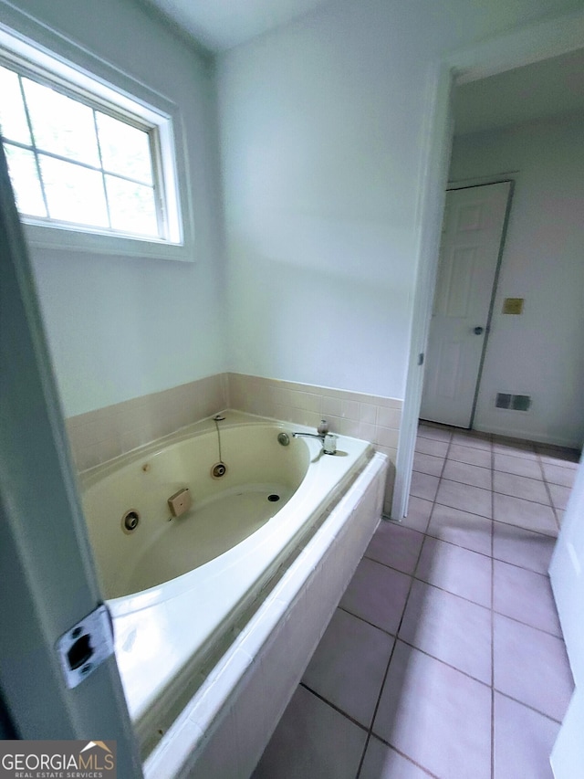 full bath featuring a tub with jets and tile patterned flooring