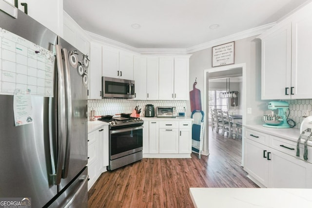 kitchen featuring stainless steel appliances, light countertops, decorative backsplash, dark wood-style floors, and white cabinets