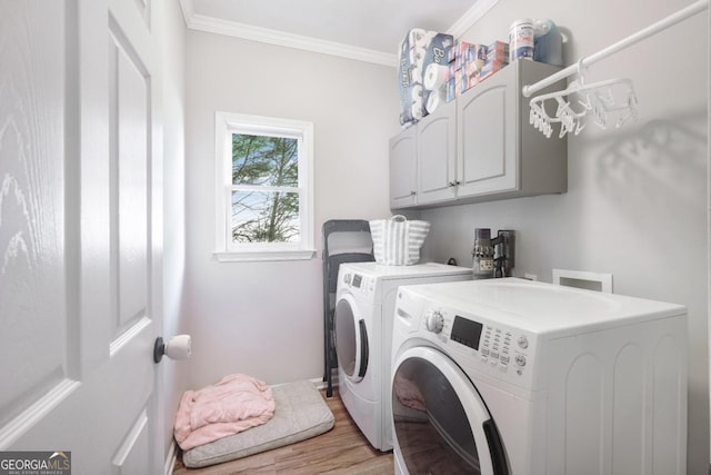 washroom featuring cabinet space, independent washer and dryer, ornamental molding, and light wood-style floors