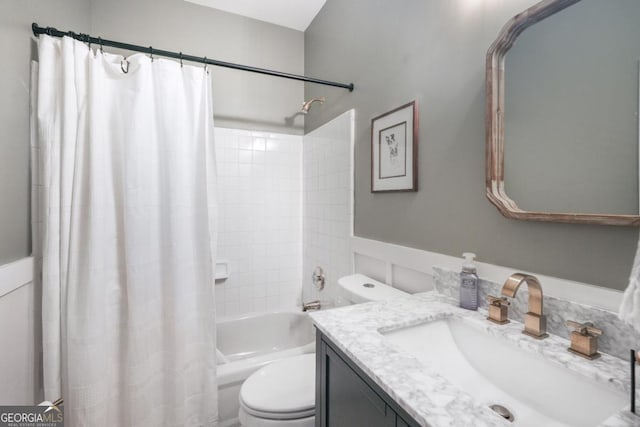 full bathroom with toilet, vanity, shower / bath combination with curtain, and a wainscoted wall