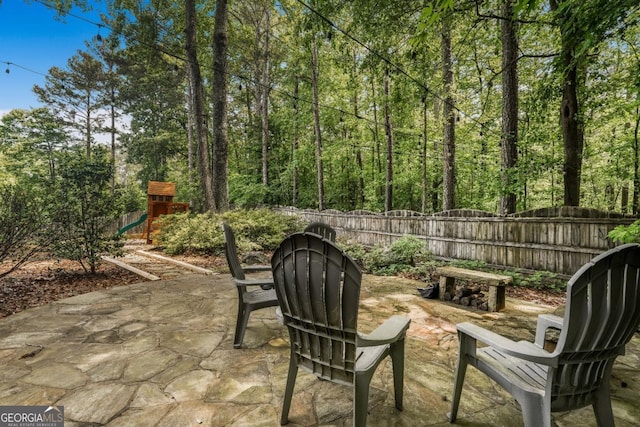 view of patio featuring a playground and a fenced backyard