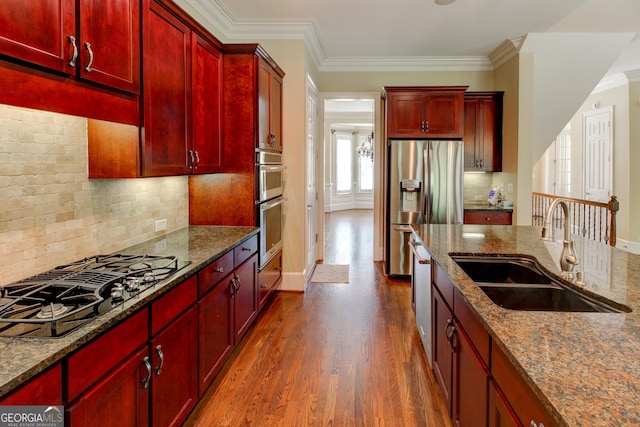 7520 Ledgewood Way, Suwanee, GA 30024 - kitchen with reddish brown cabinets, stainless steel appliances, dark wood finished floors, dark stone counters, and ornamental molding