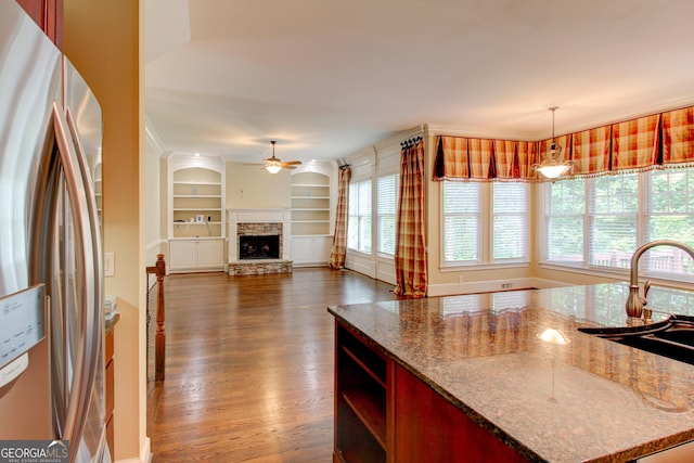 7520 Ledgewood Way, Suwanee, GA 30024 - kitchen featuring stainless steel fridge, a ceiling fan, dark wood-type flooring, a stone fireplace, and built in features