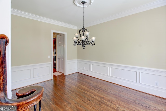 7520 Ledgewood Way, Suwanee, GA 30024 - unfurnished dining area featuring ornamental molding, a chandelier, a wainscoted wall, and dark wood-type flooring