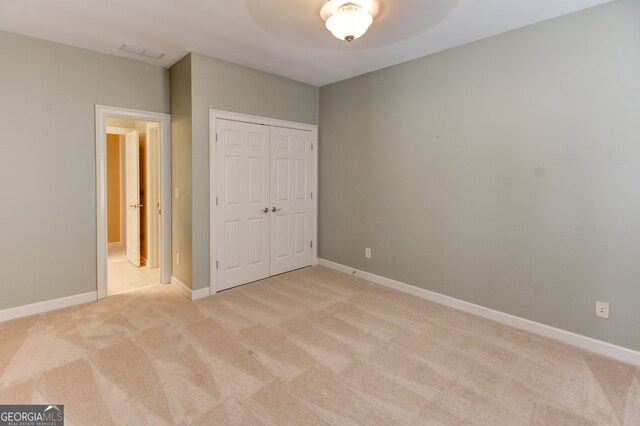7520 Ledgewood Way, Suwanee, GA 30024 - unfurnished bedroom featuring light carpet, a closet, and ceiling fan