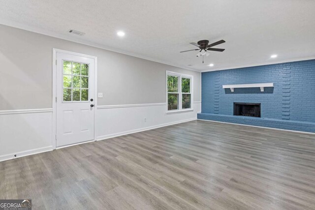 unfurnished living room with ceiling fan, wood finished floors, recessed lighting, a fireplace, and ornamental molding
