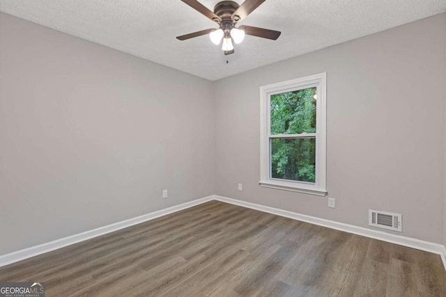 spare room featuring wood finished floors, baseboards, a textured ceiling, and ceiling fan