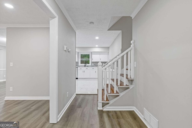 foyer entrance featuring stairway, wood finished floors, baseboards, a textured ceiling, and recessed lighting