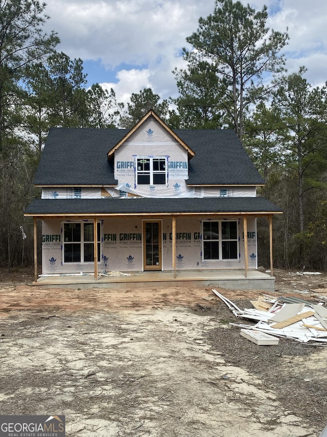 view of front facade with a porch and roof with shingles