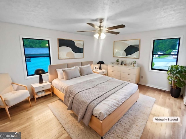 2325 Sebring Ct SW, Marietta, GA 30064 - bedroom with light wood-style flooring, a ceiling fan, baseboards, and a textured ceiling