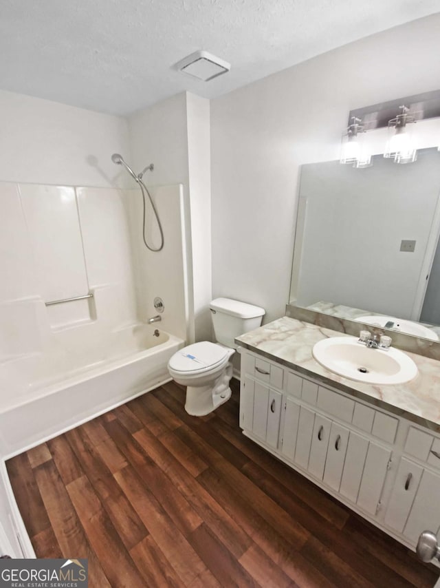 2325 Sebring Ct SW, Marietta, GA 30064 - bathroom featuring wood finished floors, shower / bathtub combination, toilet, vanity, and a textured ceiling