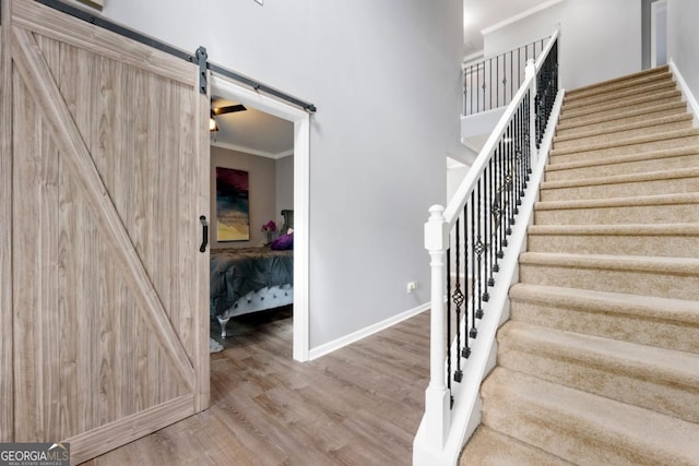 1892 Ivy View Walk, Loganville, GA 30052 - staircase featuring a barn door, ornamental molding, wood finished floors, and baseboards