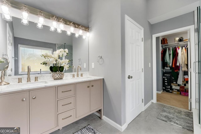 1892 Ivy View Walk, Loganville, GA 30052 - bathroom featuring double vanity, tile patterned floors, baseboards, and a spacious closet