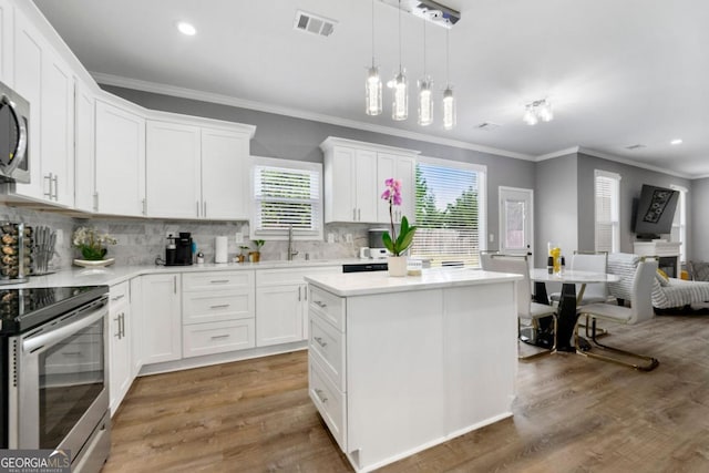 1892 Ivy View Walk, Loganville, GA 30052 - kitchen featuring stainless steel electric range, crown molding, plenty of natural light, open floor plan, and light countertops